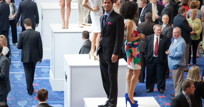 Models showcasing the new spring line atop of large pedestals during a networking reception were a unique sponsor benefit for this fashion retailer at a corporate event.