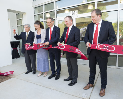 The cutting of a branded ribbon marked the grand opening of a North American headquarters.